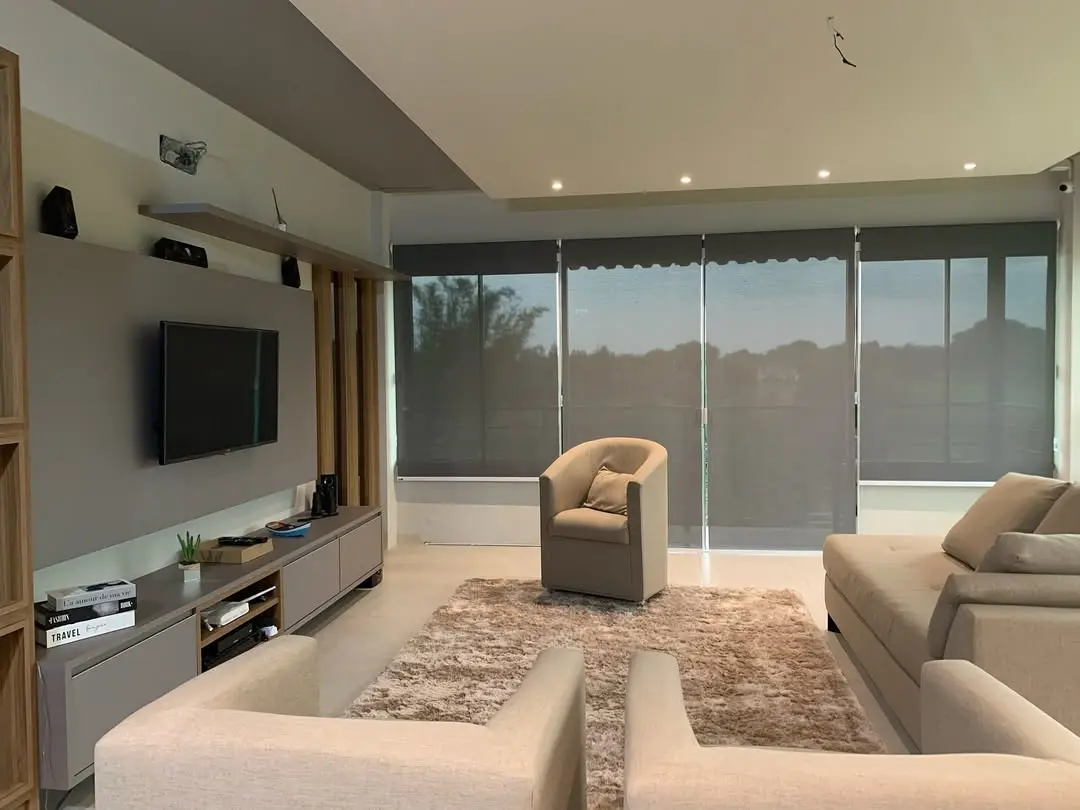 Sala de estar com persianas rolô tela solar escura