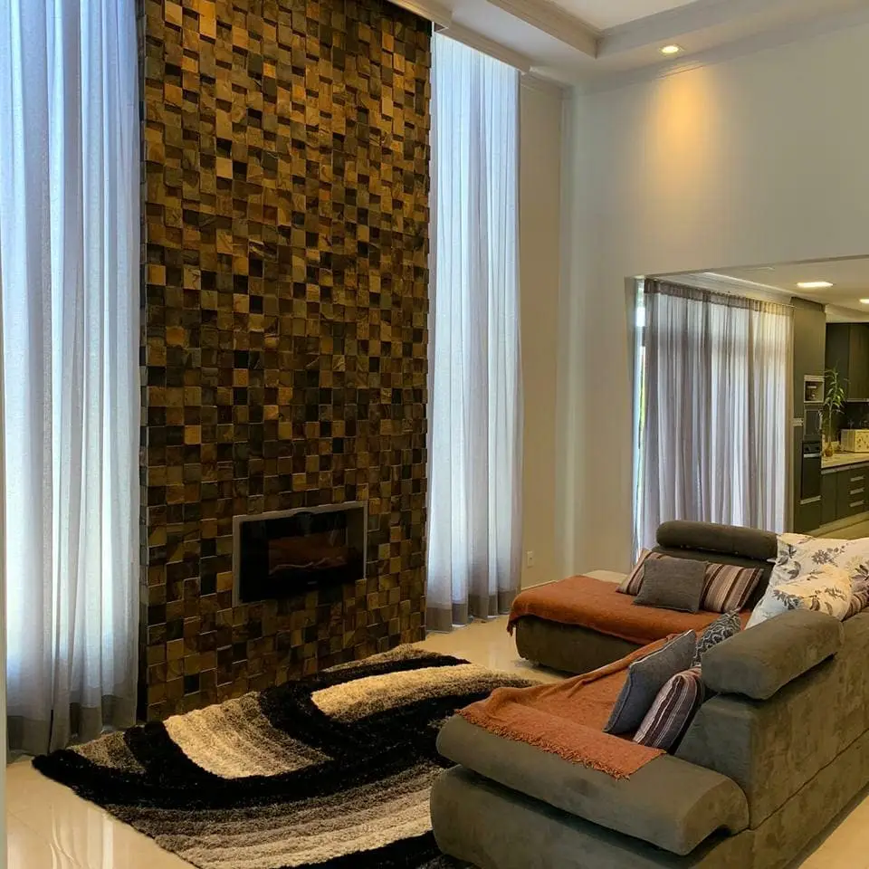 Sala com pé-direito alto e cortinas de voil