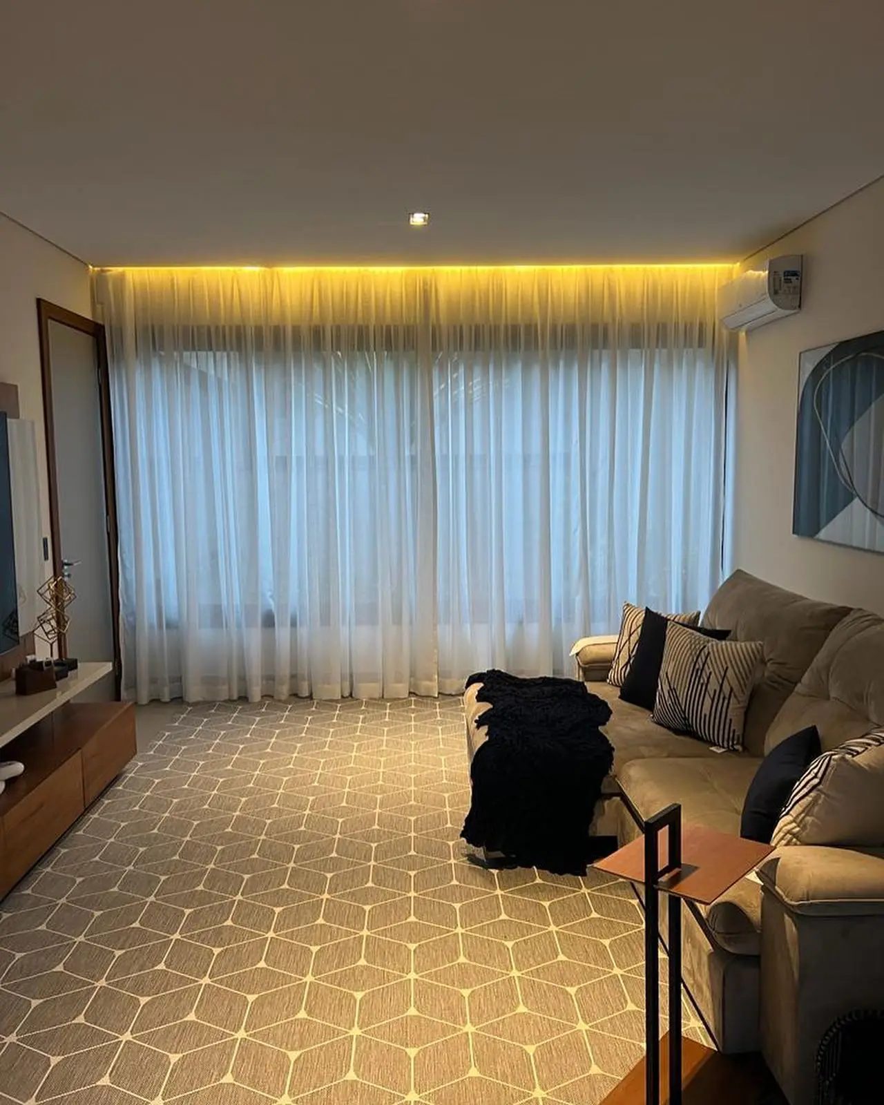 Sala de TV com cortina de voil e fita de LED